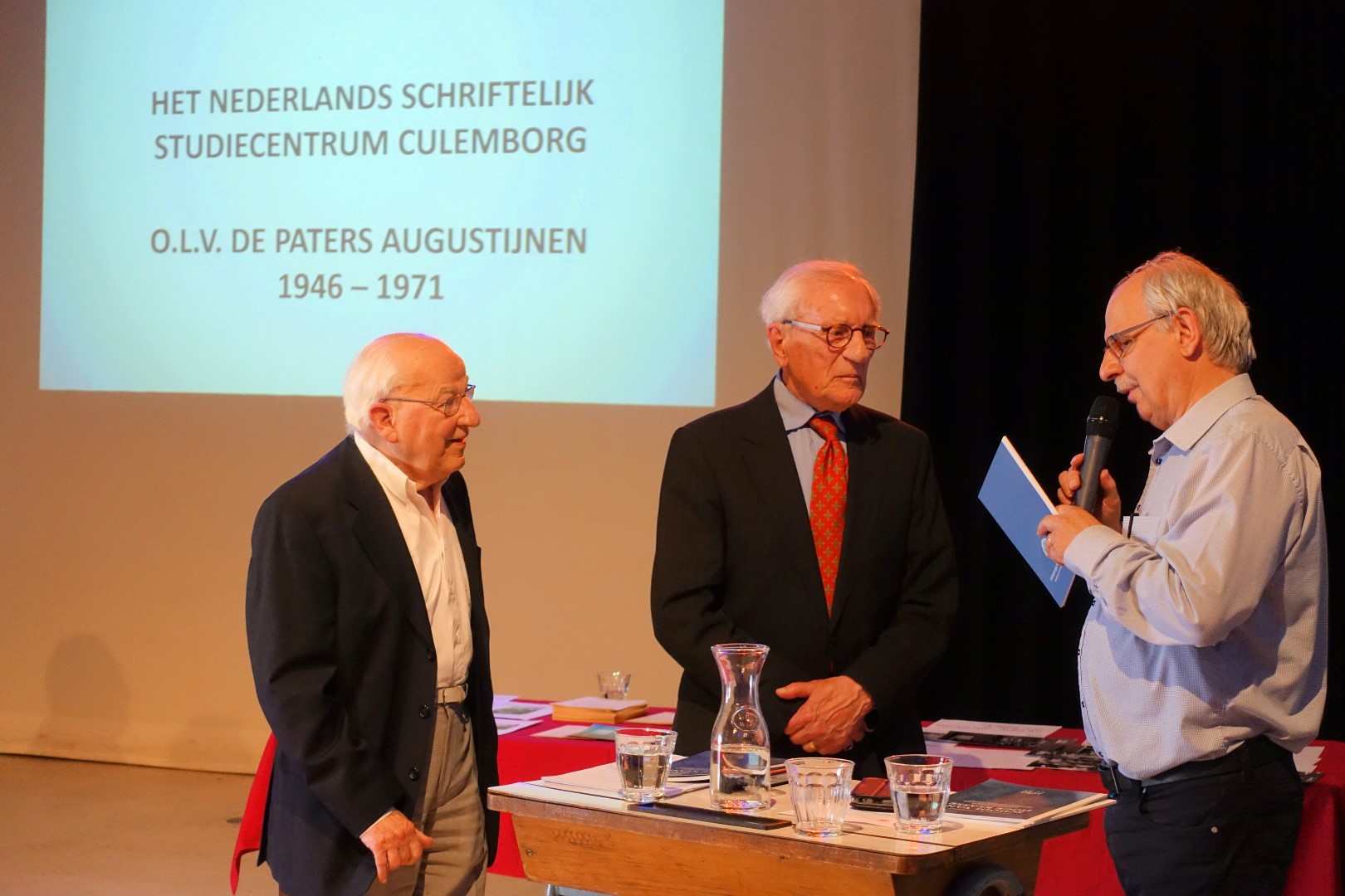 Overhandiging van de eerste exemplaren aan Ton van Daal (links) en Johan van Blokland (rechts) door Joop de Vries